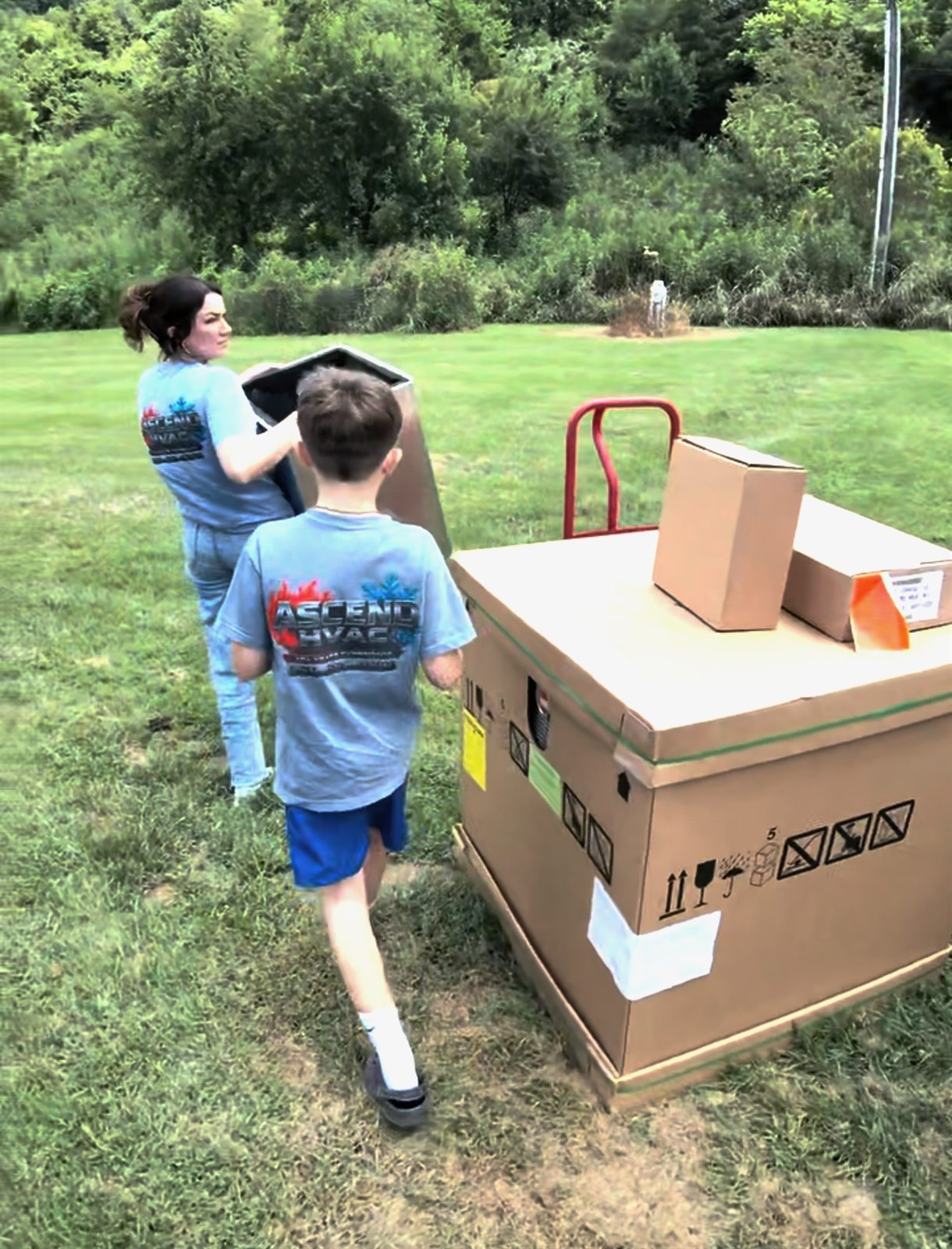 Ascend HVAC family members helping move equipment at a local installation