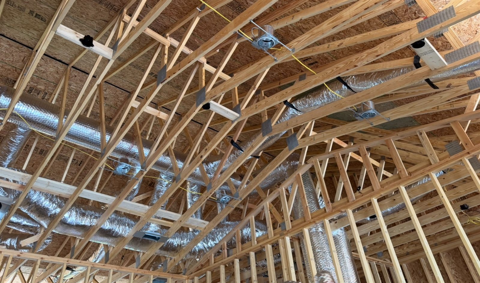 HVAC ductwork installed through new construction roof framing