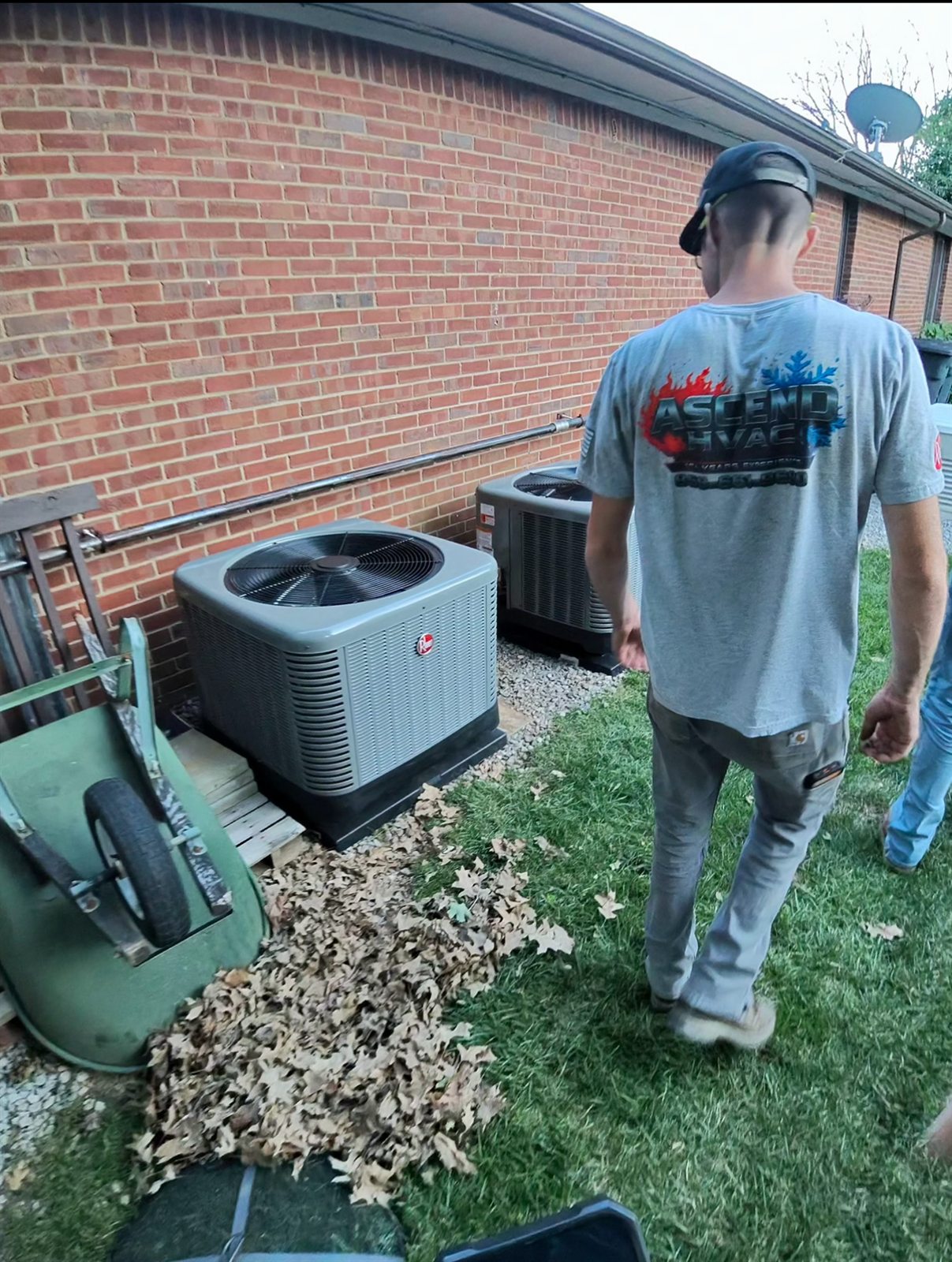Ascend HVAC technician inspecting Rheem outdoor air conditioning units